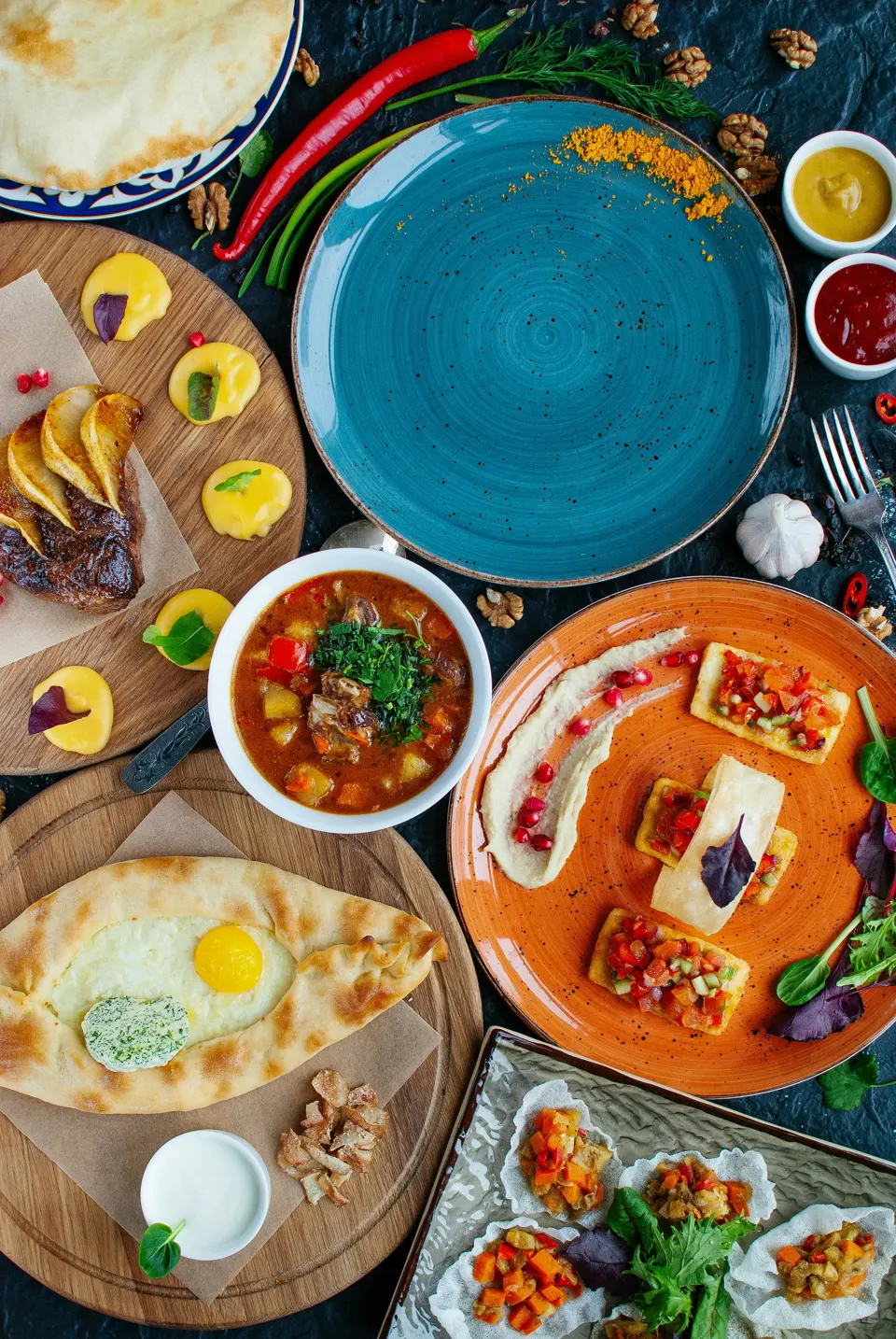 Georgian food spread with khachapuri, stews, appetizers, and sauces
