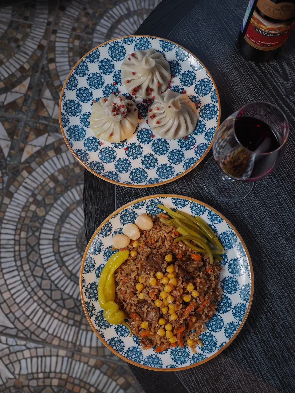 Khinkali dumplings with Georgian bean dish, pickles, and wine